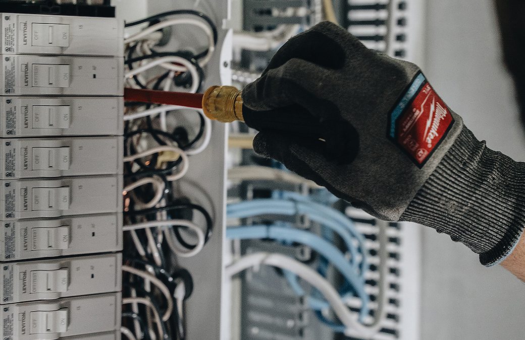 Electrician wiring an automatic transfer switch for a home generator in Calgary